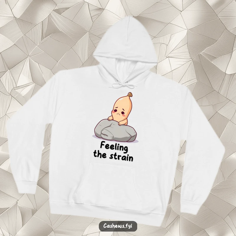 Funny cashew hoodie showing a determined cashew with a grimace struggling to lift a giant pebble, perfect for cold days.
