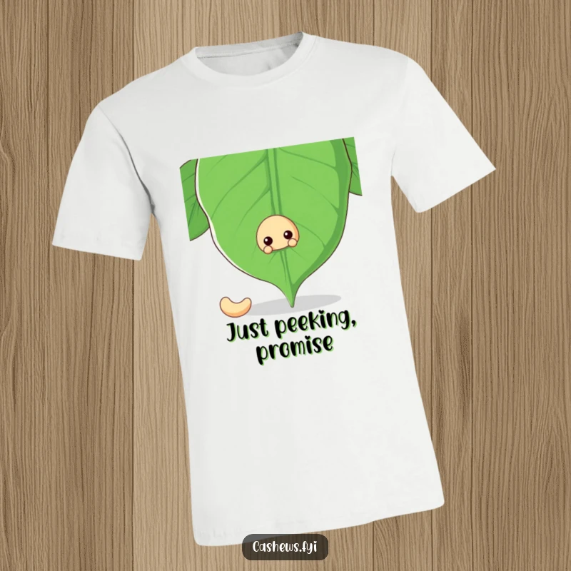 Funny t-shirt featuring a cashew nut peeking mischievously from behind a giant cashew leaf, exuding a playful and hidden charm.